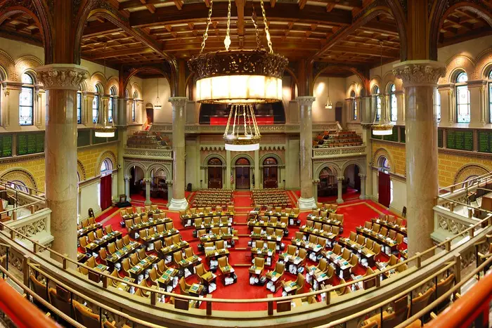A photograph showing the empty NY State Assembly chambers